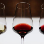 Trois verres de vin blanc et rouge alignés pour une dégustation pédagogique chez Sensation Vin.